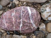 Weißer Stein neben rötlichem Stein mit weißer Ringmaserung